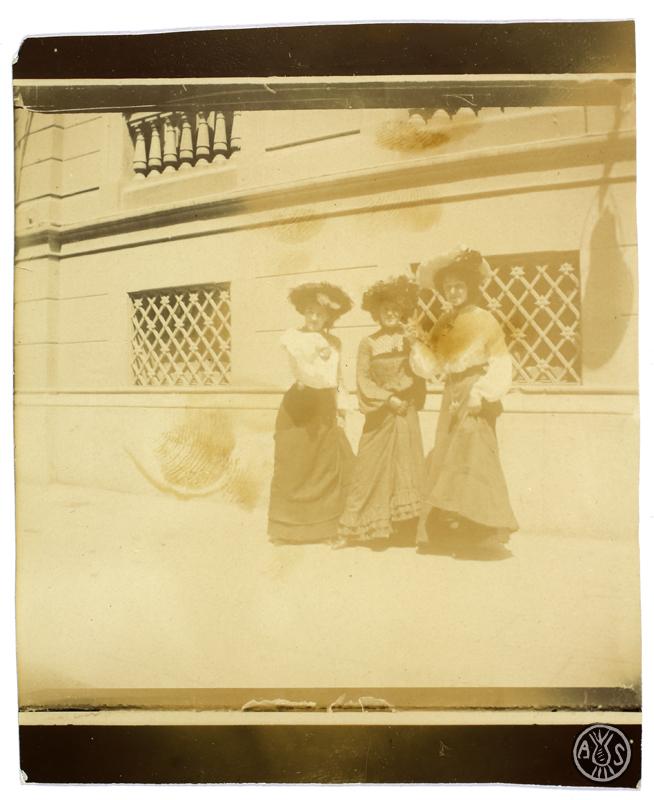 Tres dones davant la façana d'un edifici. S.l.