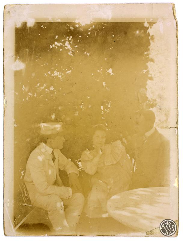 Tres persones assegudes en un jardí. S.l.