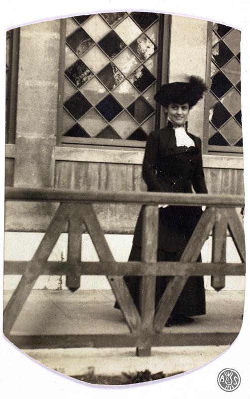 Dona darrera d'una tanca de fusta. S.l.