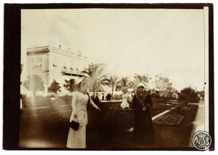 Dues noies passejant per un jardí. S.l.