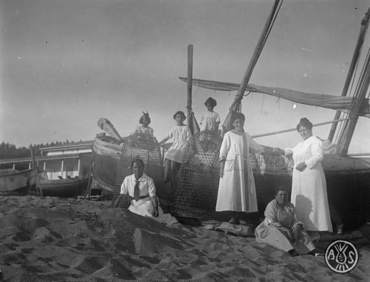 Dones davant d'una barca a Caldes d'Estrac