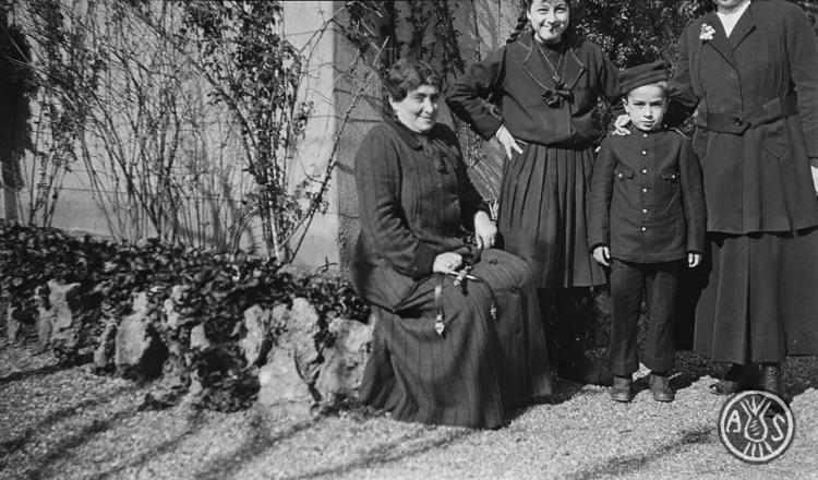Dones amb un nen amb uniforme militar
