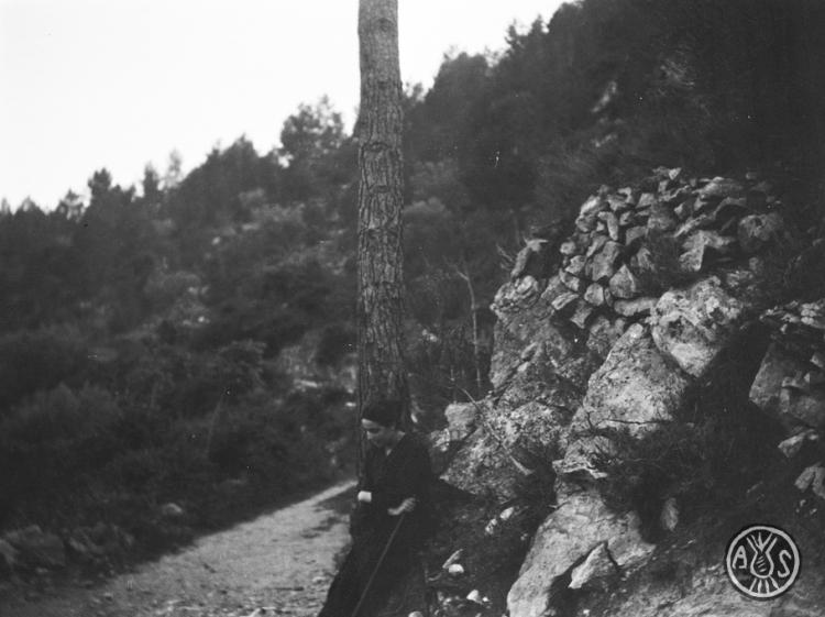 Dona descansant en un camí