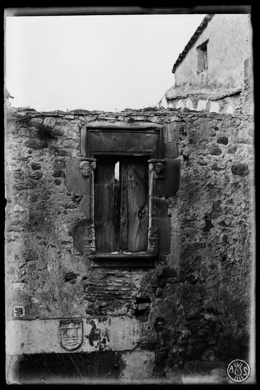 Restes dun edifici a Palau-solità i Plegamans. Finestra i escut de teixidor a la llinda de pedra de la porta