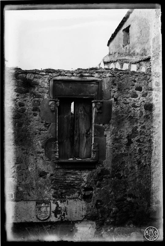 Restes dun edifici a Palau-solità i Plegamans. Finestra i escut de teixidor a la llinda de pedra de la porta