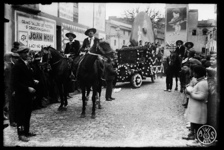 Carrossa i comparses de la cavalcada de Carnestoltes al seu pas per la plaça de l'Àngel. Sabadell