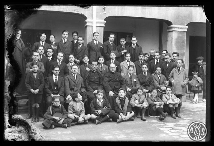 Junta i membres de la Congregació Mariana al pati de les Germanetes dels Ancians Desemparats en la presentació del nou director Pare Tura i el comiat del pare Joan Serrabassa