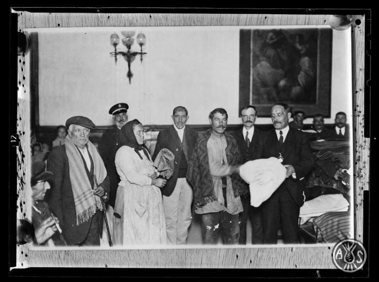 Repartiment de roba als pobres per part dels senyors Vicenç Mayor i Josep Roure membres de l' Acadèmia Catòlica. Alberg del pobre de Sabadell