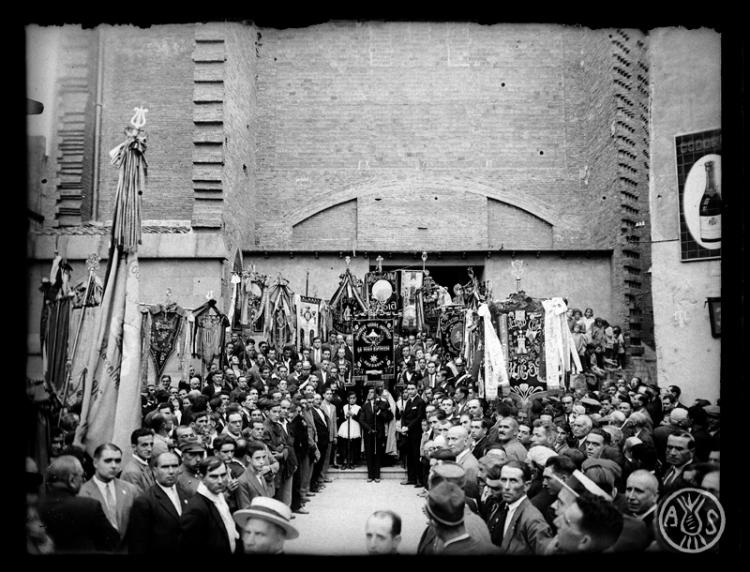 Concentració d'estendards i banderes dels cors populars d'en Clavé davant de la porta de l'església de Sant Feliu. Sabadell