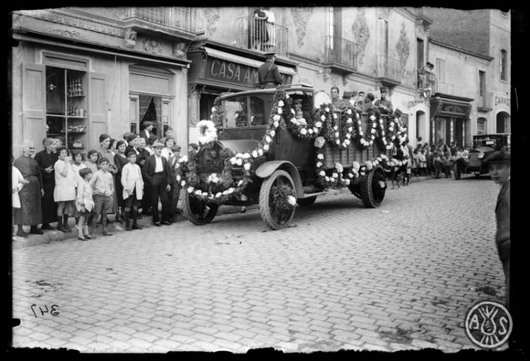 La Banda Militar de Música en un camió al seu pas per la Via Massagué davant de la casa Ambros. Dia de Sant Cristòfol. Sabadell