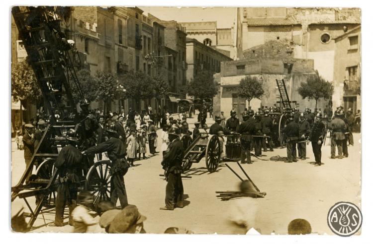 Demostració del cos de bombers a la plaça Sant Roc. Edició postal.