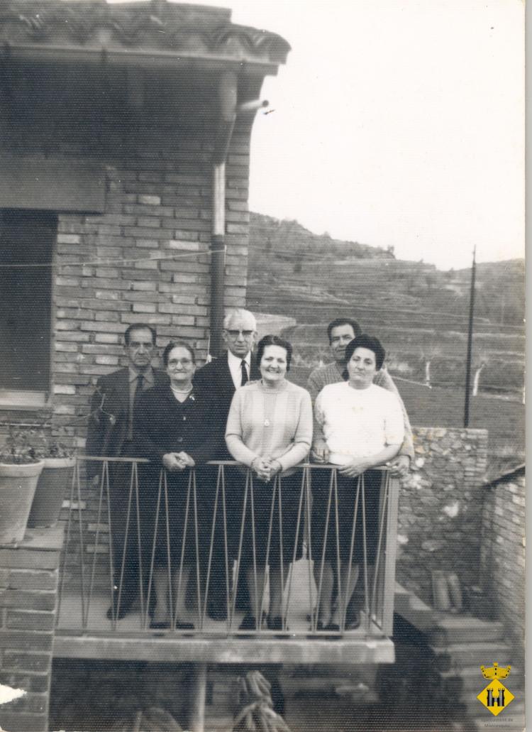 Grup de persones a un balcó d'una casa del carrer Sant Boi