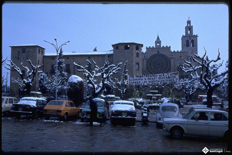 Pancarta dels treballadors de la Manufactura Aymat penjada sobre la plaça d'Octavià nevada.
