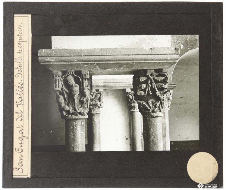 Parella de capitells, el capitell de la psicomàquia o triomf de les virtuts sobre els vicis i un capitell vegetal, ala sud del  Claustre del Monestir de Sant Cugat del Vallès.