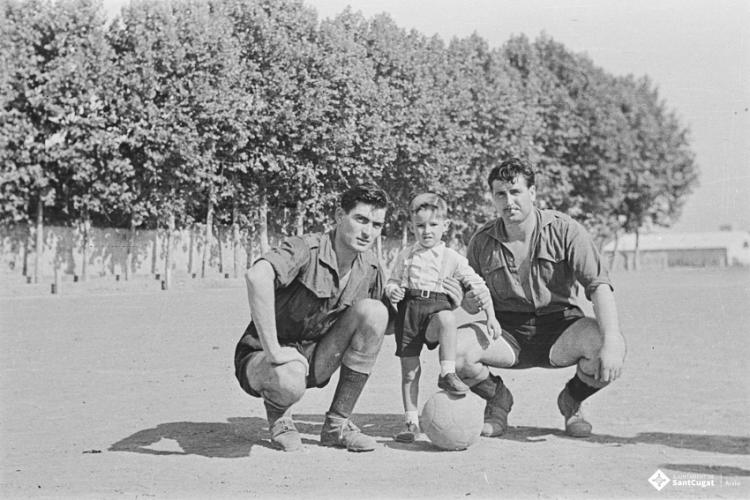 Retrat d'un infant amb dos futbolistes, a l'antic camp de futbol situat al recinte del Monestir.