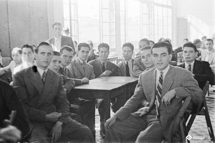 Actes de la festa inaugural de la restaurada Societat Coral La Unió Santcugatenca. Un grup d'homes asseguts a la sala del cafè de la Unió.