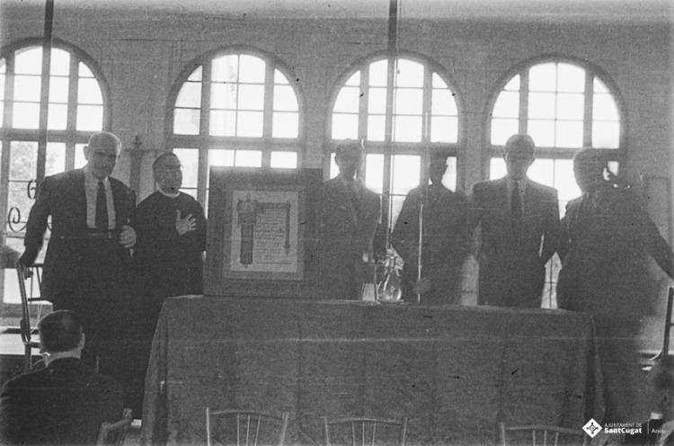 Actes de la festa inaugural de la restaurada Societat Coral La Unió Santcugatenca. Lliurament d'un pergamí - recordatori emmarcat al mossèn.