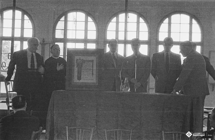 Actes de la festa inaugural de la restaurada Societat Coral La Unió Santcugatenca. Lliurament d'un pergamí - recordatori emmarcat al mossèn.