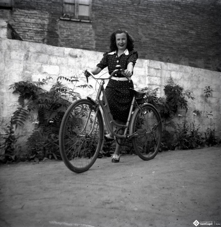 Dona en bicicleta retratada al pati del fotògraf.