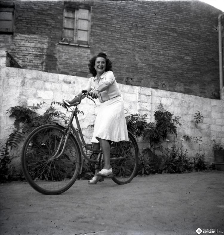 Paquita Casajuana en bicicleta, retratada al pati de Cal Cabanas.