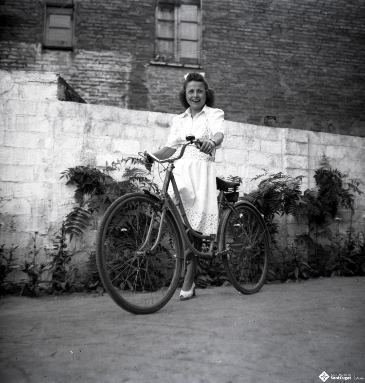 Dona en bicicleta retratada al pati del fotògraf.