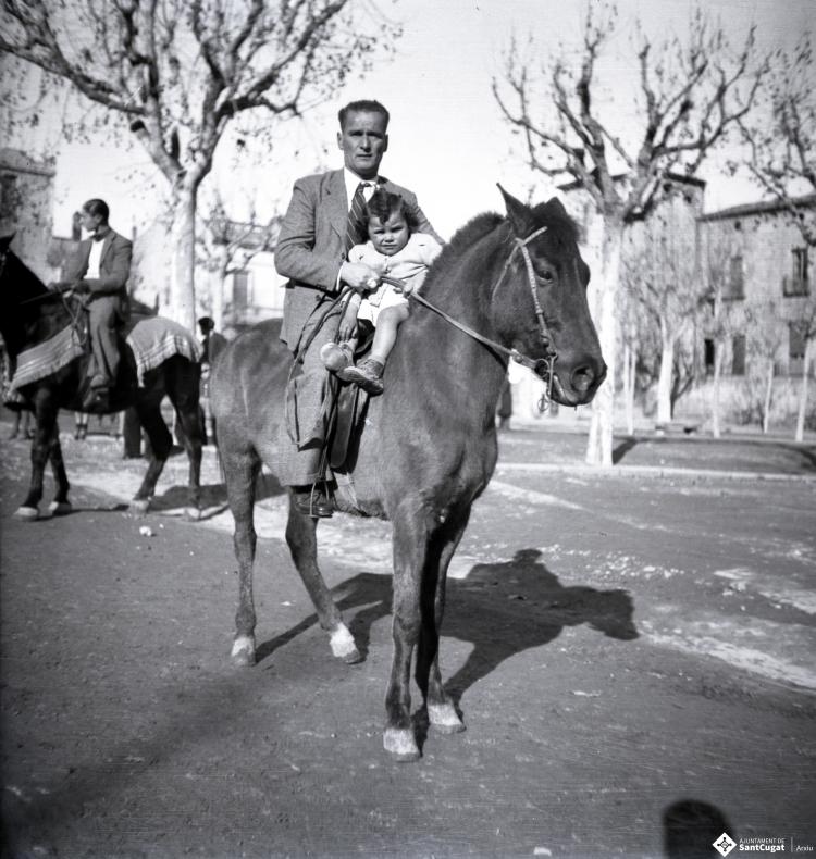 Tres Tombs, retrat d'un home i una nena a cavall, a la plaça d'Octavià.