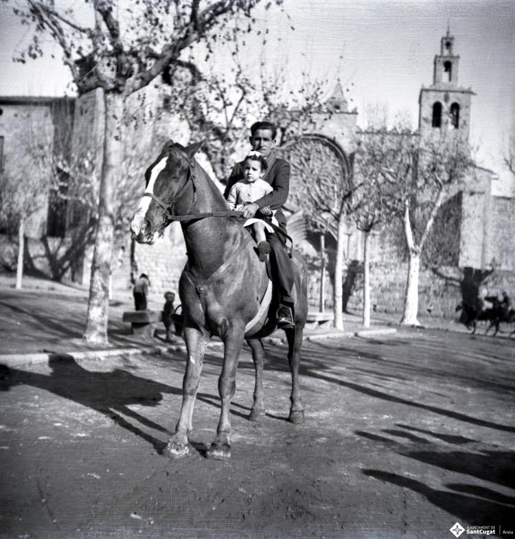 Tres Tombs, retrat d'un home i una nena a cavall, a la plaça d'Octavià.