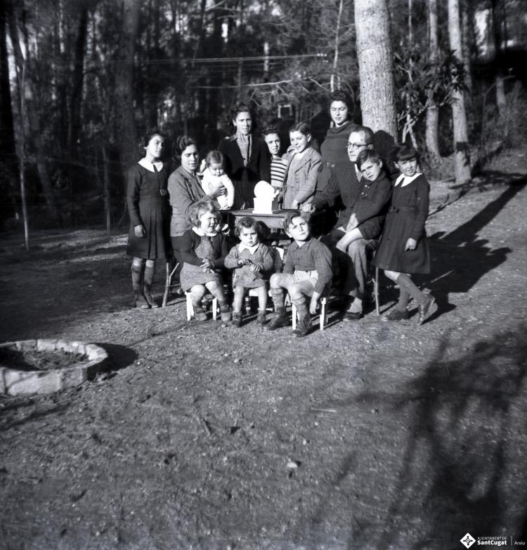 Retrat d'una família al jardí d'un xalet.