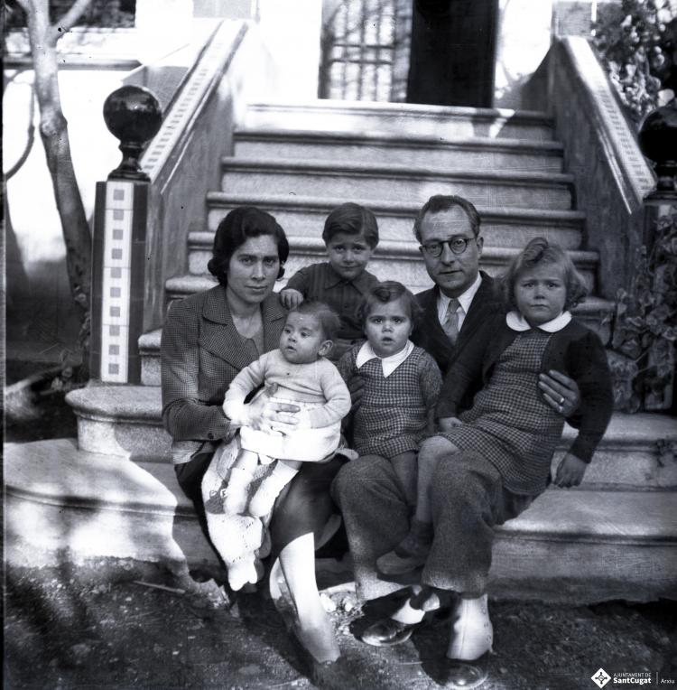 Retrat d'una família al jardí d'un xalet.