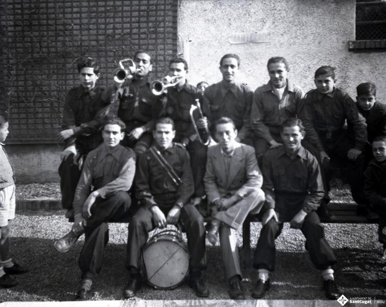 Celebració als Quatre Cantons davant de la seu de la Falange de Sant Cugat del Vallès i desfilada amb banda de músics als Quatre Cantons.