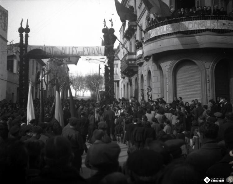 Celebració als Quatre Cantons davant de la seu de la Falange de Sant Cugat del Vallès i desfilada amb banda de músics als Quatre Cantons.