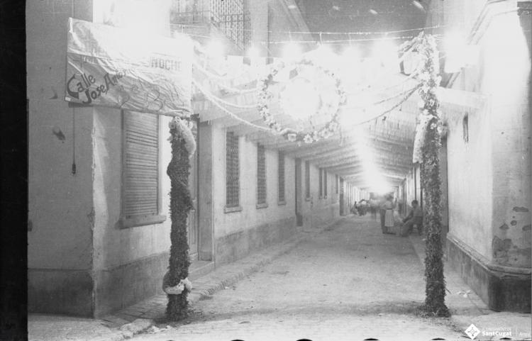 Carrer de Xerric, de nit, engalanat amb motiu d'unes festes.