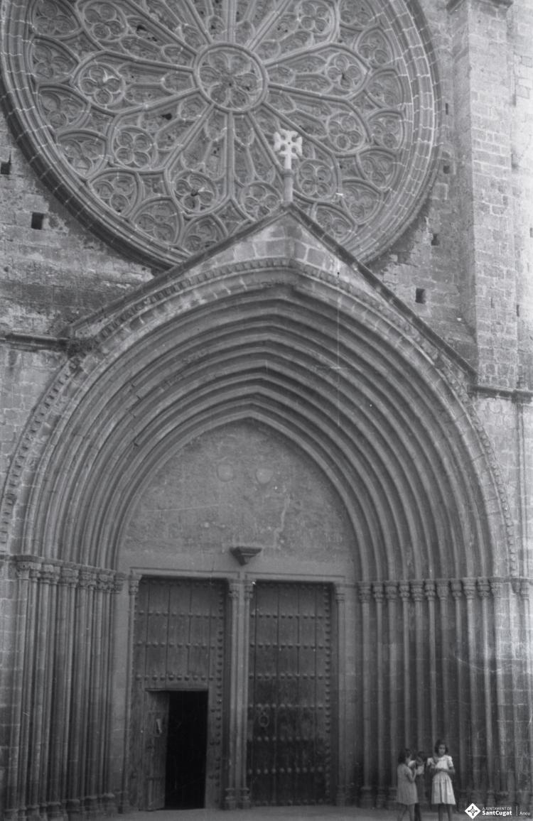 Dues noies davant la porta principal de l'església de Sant Pere d'Octavià.