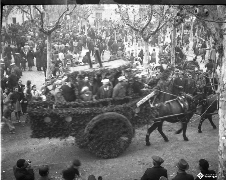 Festa de Sant Antoni Abat. Carruatge enramat amb forma de vaixell, amb el rètol: Ciutat de Regalèssia, amb els membres de la Penya Regalèssia vestits de mariners durant la passada.