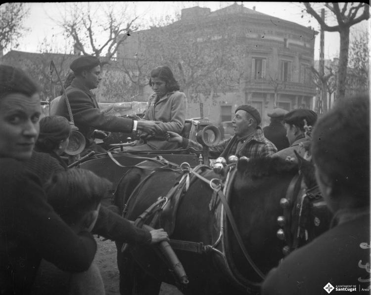 Festa de Sant Antoni Abat. Una noia en un carruatge, al fons l'edifici de Cal Gerrer.