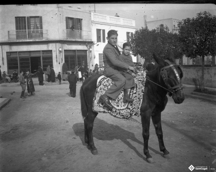 Festa de Sant Antoni Abat. Retrat de dos joves dalt d'un ruc a la plaça de Lluís Millet.