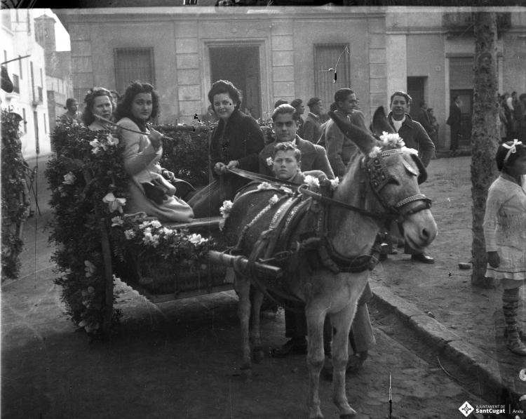 Festa de Sant Antoni Abat. Retrat de un grup de joves dalt d'un carro al seu pas per la plaça de Barcelona.