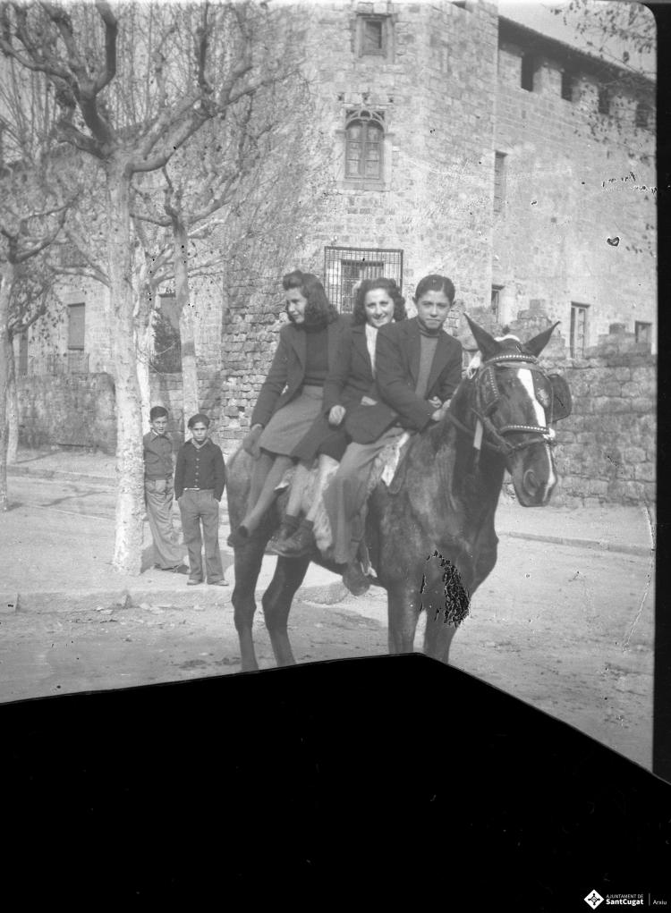 Festa de Sant Antoni Abat. Retrat de tres joves dalt d'un cavall a la plaça d'Octavià.