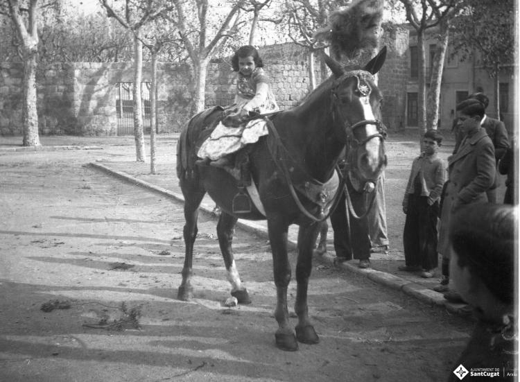 Festa de Sant Antoni Abat. Retrat d'una nena sobre un cavall a la plaça d'Octavià.