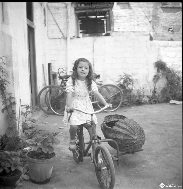 Retrat de l'Elisabet  Cabanas sobre una bicicletaque du un sidecar de vímet.