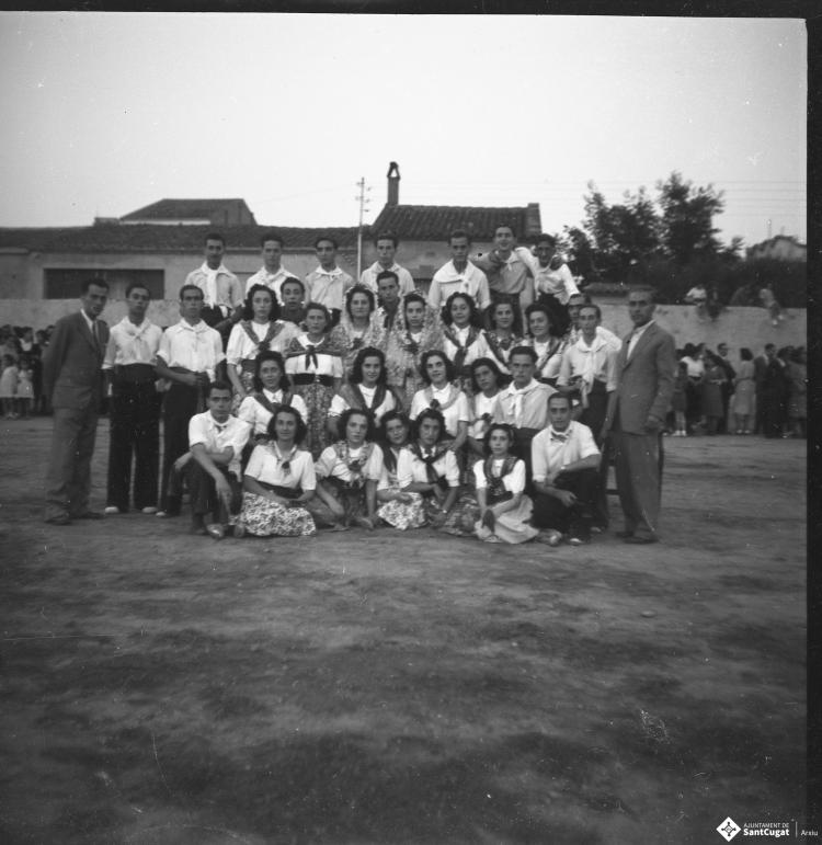 Retrat d'un grup de joves balladores i balladors, al camp de futbol que hi havia prop del monestir.