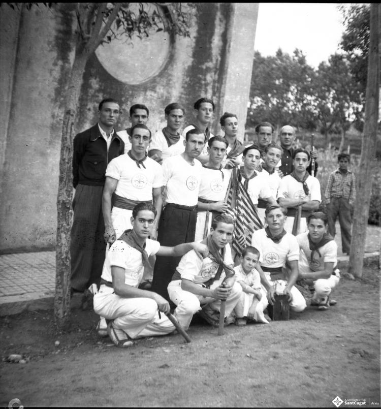 Festa major. Retrat de grup dels bastoners amb el seu mestre Manel Farrés, davant de la Unió.