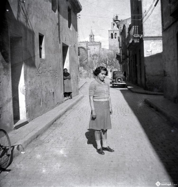 Retrat d'una noia, dempeus, al mig del carrer de Santiago Rusiñol.