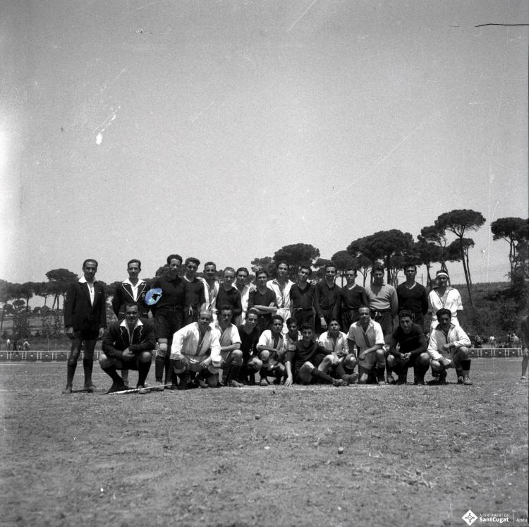 Activitats festives. Retrat dels components dels equips de futbol. Ubicació no identificada, a prop hi ha una catenària d'un tren.