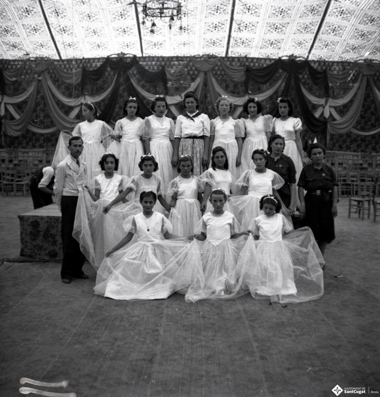 Festa Major. Ball a l'envelat, retrat d'un grup de nenes, probablement de la secció infantil de l'Esbart Dansaire, acompanyades per  Manuel Farrés i dues dones uniformades.