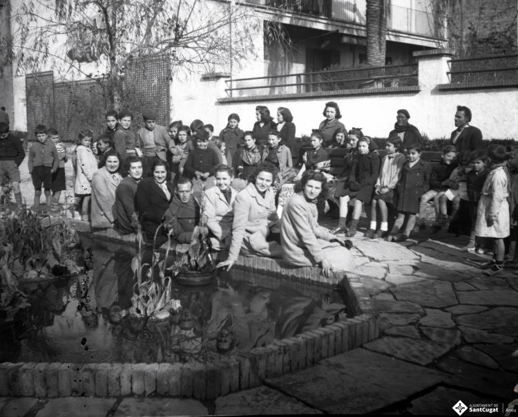 Celebració davant de la seu de la Falange a Cal Barbany. Retrat de grup a l'estany de la plaça del Quatre Cantons.