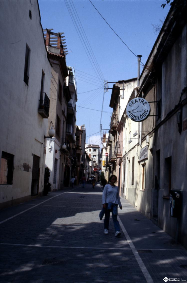 Carrer de Santa Maria, en primer terme el rètol d'un centre de podologia.