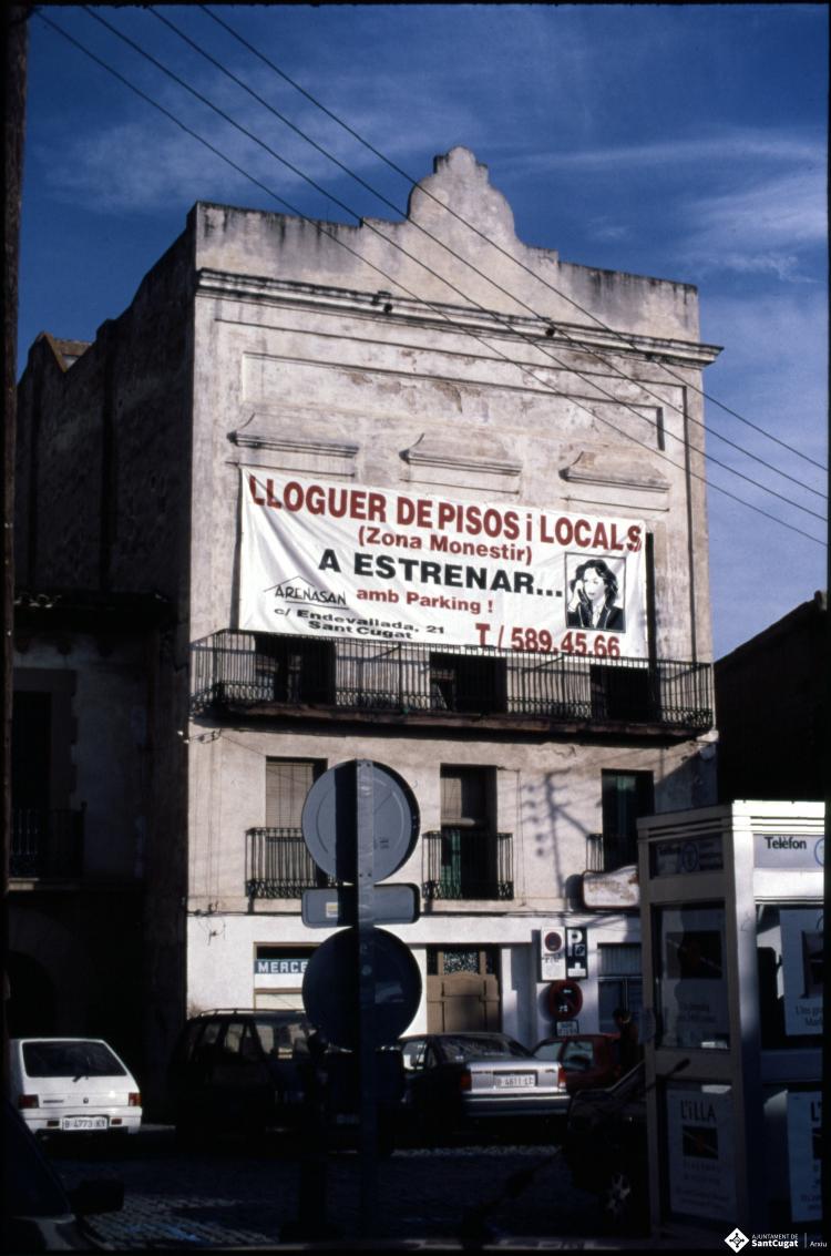 Rètol publicitari anunciant lloguers de pisos i locals, sobre la façana d'un edifici de la plaça de Pere Sant, de Sant Cugat del Vallès.