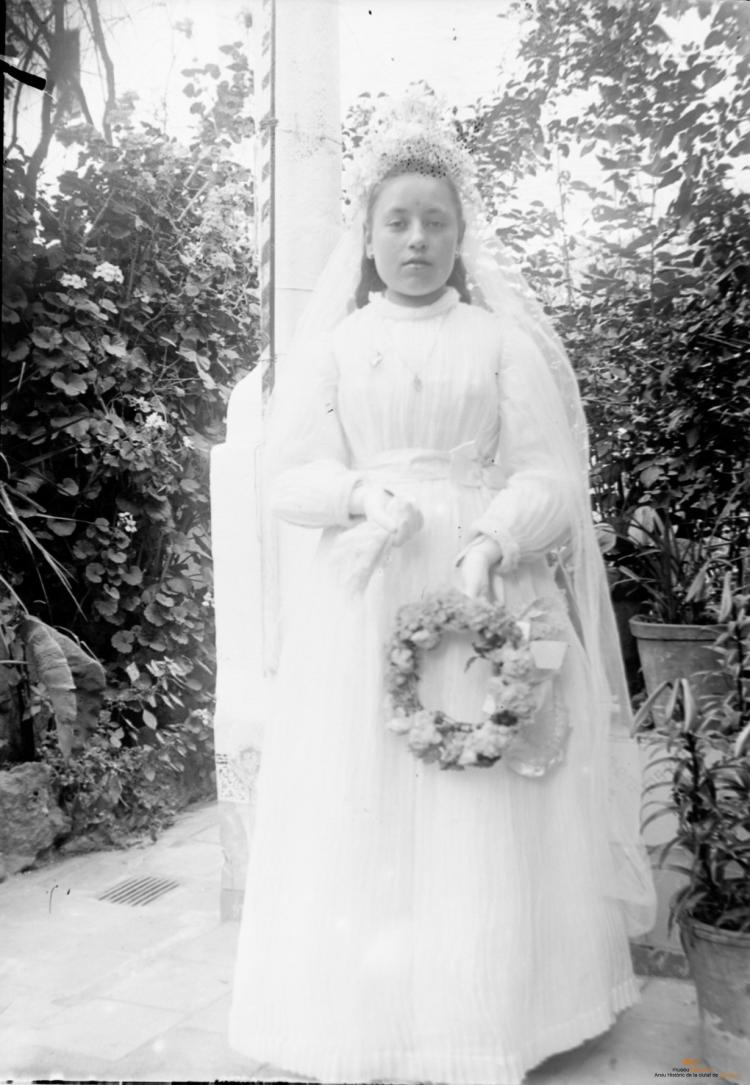 Nena de comunió al badiu o jardí