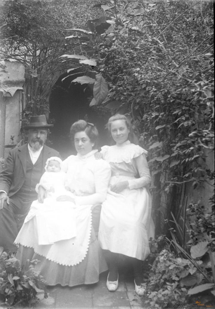 Home, dona, noia i un bebè al badiu o jardí
